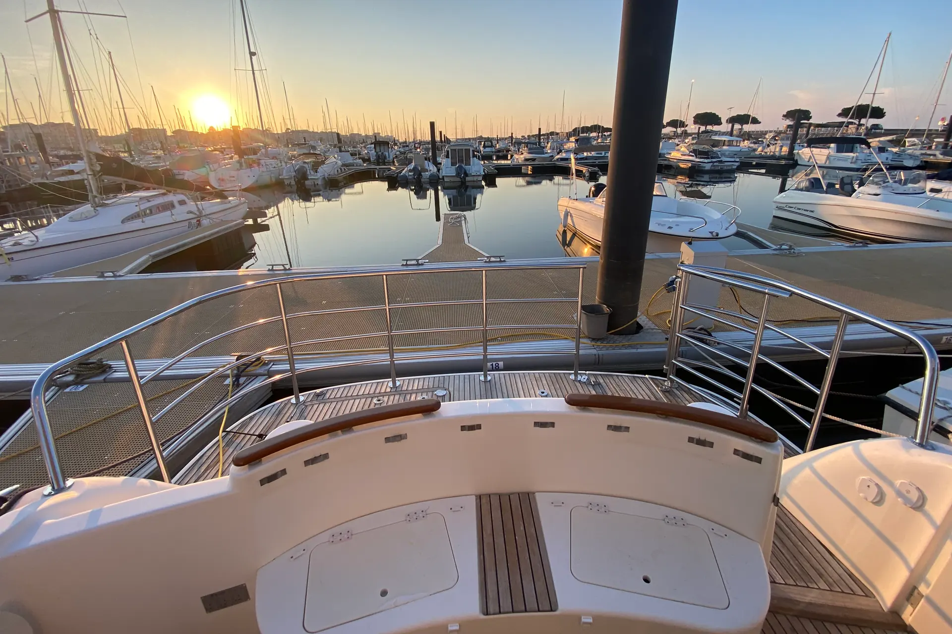 Balcon et main courante inox sur-mesure sur un bateau à quai au couchant, accastillage réalisé par Creal'Inox sur le Bassin d'Arcachon